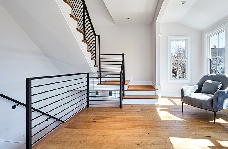 Bright and airy living room with light blonde Chardonnay floors, crisp white walls, and contemporary minimalist furniture like a plush beige couch, creating a fresh and calming Scandinavian-inspired space.