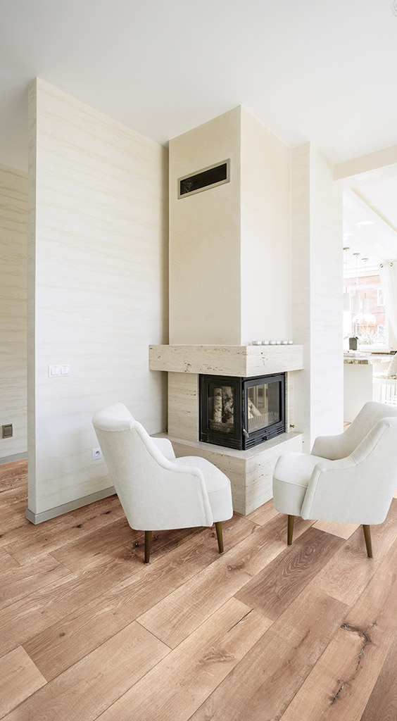 Inviting open concept living space featuring warm Milano floors, white shiplap walls, and modern farmhouse style decor with a rustic wooden beam ceiling, creating a cozy yet bright atmosphere.